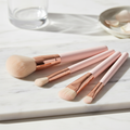 Professional Makeup Brush Set with rose gold ferrules on marble surface